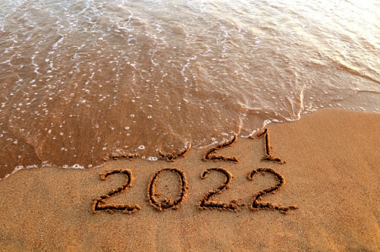 New year 2022 and old year 2021 on sandy beach with waves